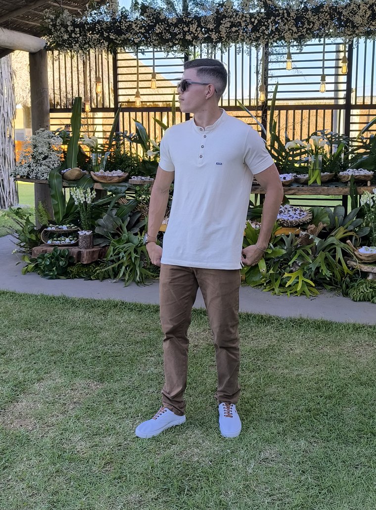 Artur Gabriel em pé, de camiseta clara e óculos escuros